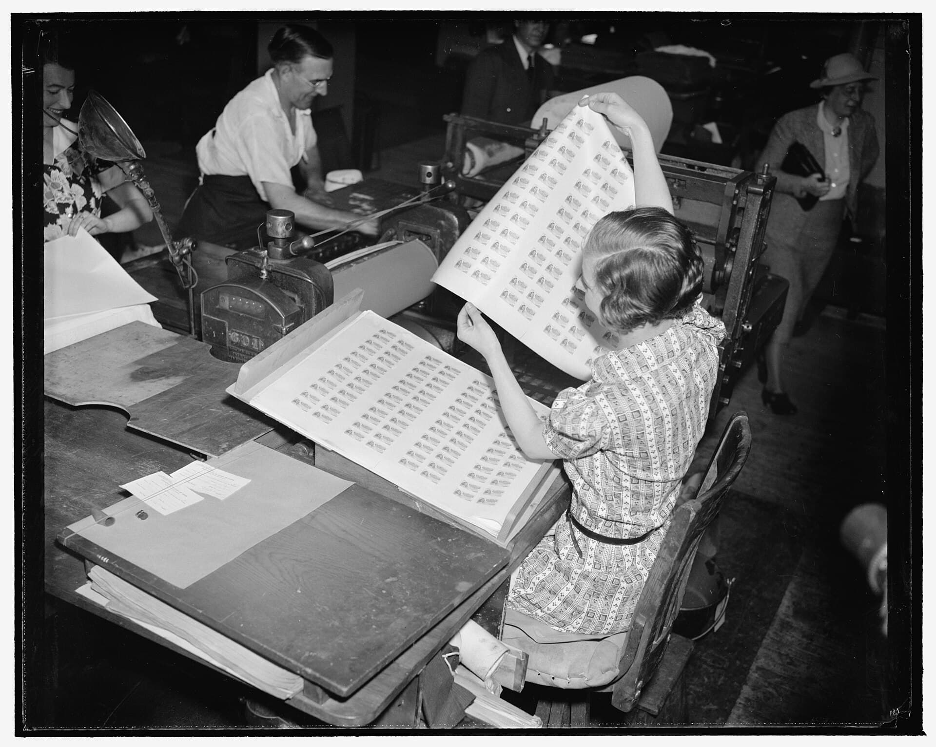 A printer lifts a freshly printed sheet of food stamps from the press in Washington, D.C.