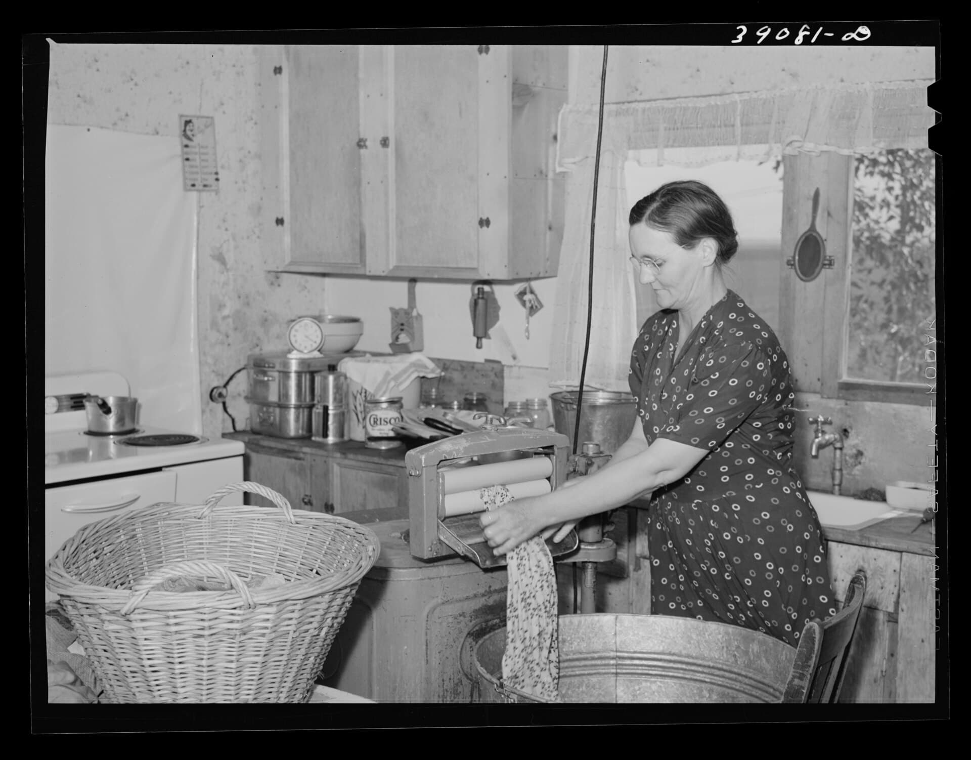 Mrs. Botner, whose family took part in a Farm Security Administration program, at an electric wringer in 1941