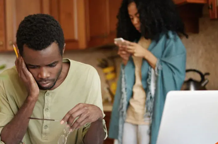 A man going through paperwork at his laptop at home