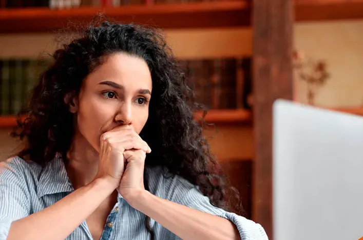 A woman thinking while reading at home
