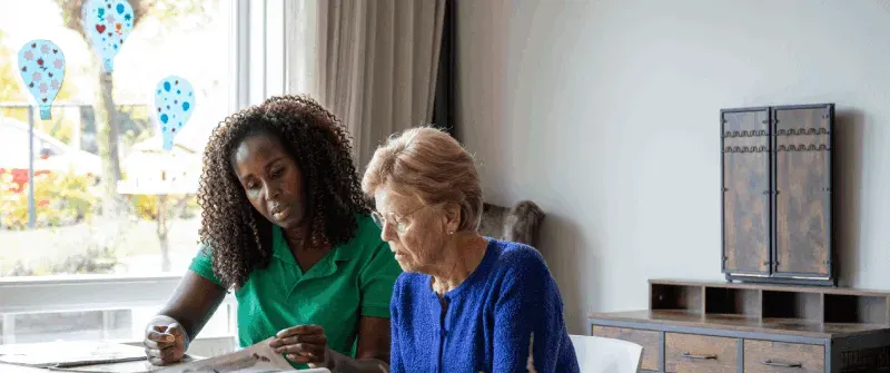 A caregiver doing a puzzle with an older woman at home
