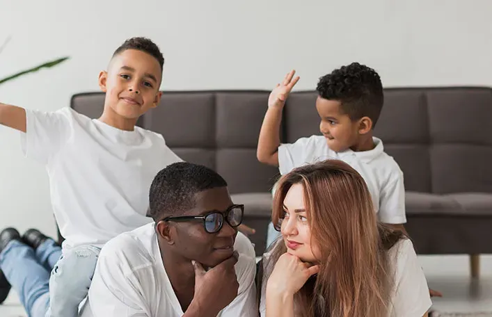 Parents relaxing on the living room floor with their two boys